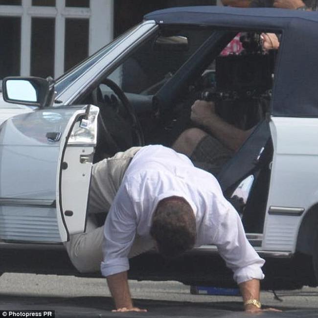 John Travolta cade dall'auto appena aver aperto la portiera